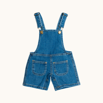 EVERYDAY DENIM OVERALLS; 100% Organic Cotton; Medium-weight denim fabric; Press snaps at the crotch for easy dressing (Size 0 & Size 1); Adjustable straps and front patch pockets; Logo badge at the back.