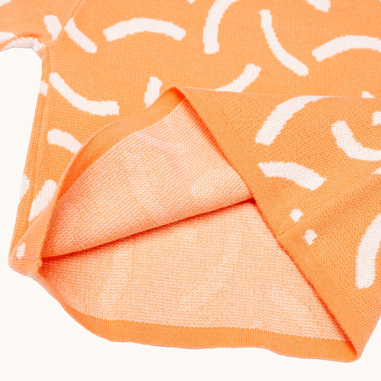KNITTED BRUSH ORGANIC TEE – CORAL/CREAM; 100% Organic Cotton; Made from GOTS-certified organic cotton; 'BRUSH' Jacquard pattern; Rolled edge at the neckband; Rib finish at hem and cuffs; Dropped shoulder; Relaxed fit