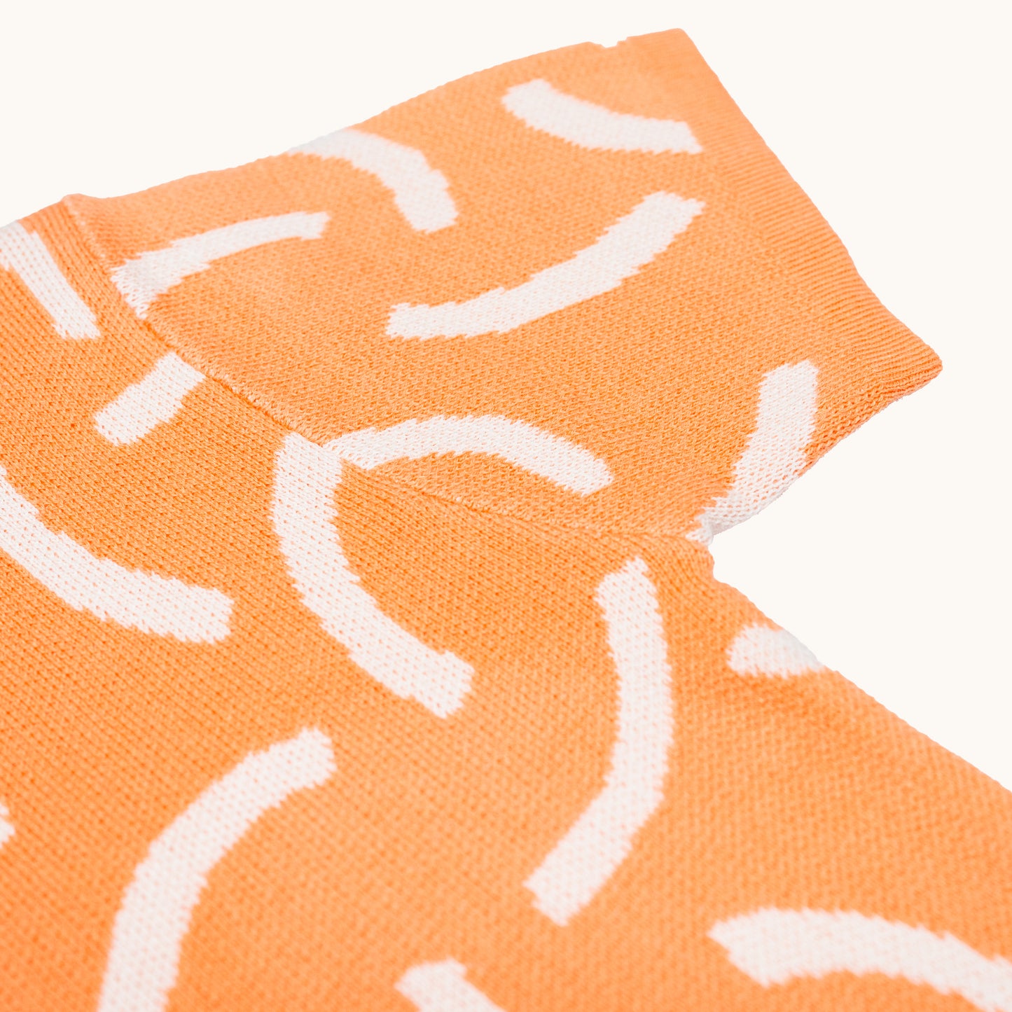 KNITTED BRUSH ORGANIC TEE – CORAL/CREAM; 100% Organic Cotton; Made from GOTS-certified organic cotton; 'BRUSH' Jacquard pattern; Rolled edge at the neckband; Rib finish at hem and cuffs; Dropped shoulder; Relaxed fit