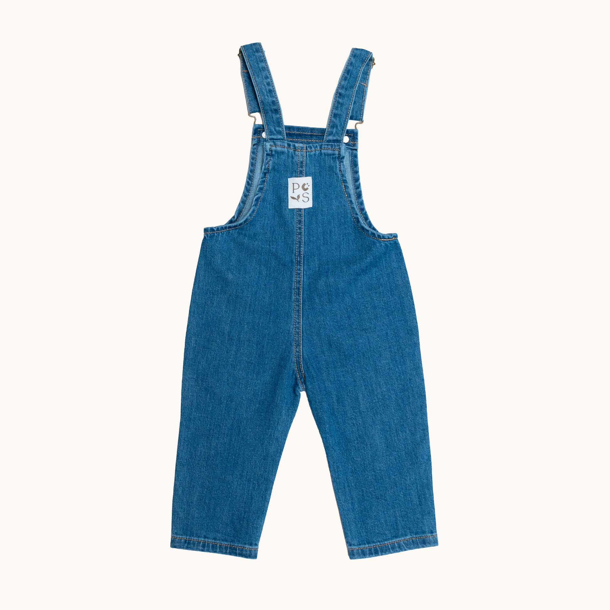 EVERYDAY DENIM OVERALLS; 100% Organic Cotton; Medium-weight denim fabric; Press snaps at the crotch for easy dressing (Size 0 & Size 1); Adjustable straps and front patch pockets; Logo badge at the back.