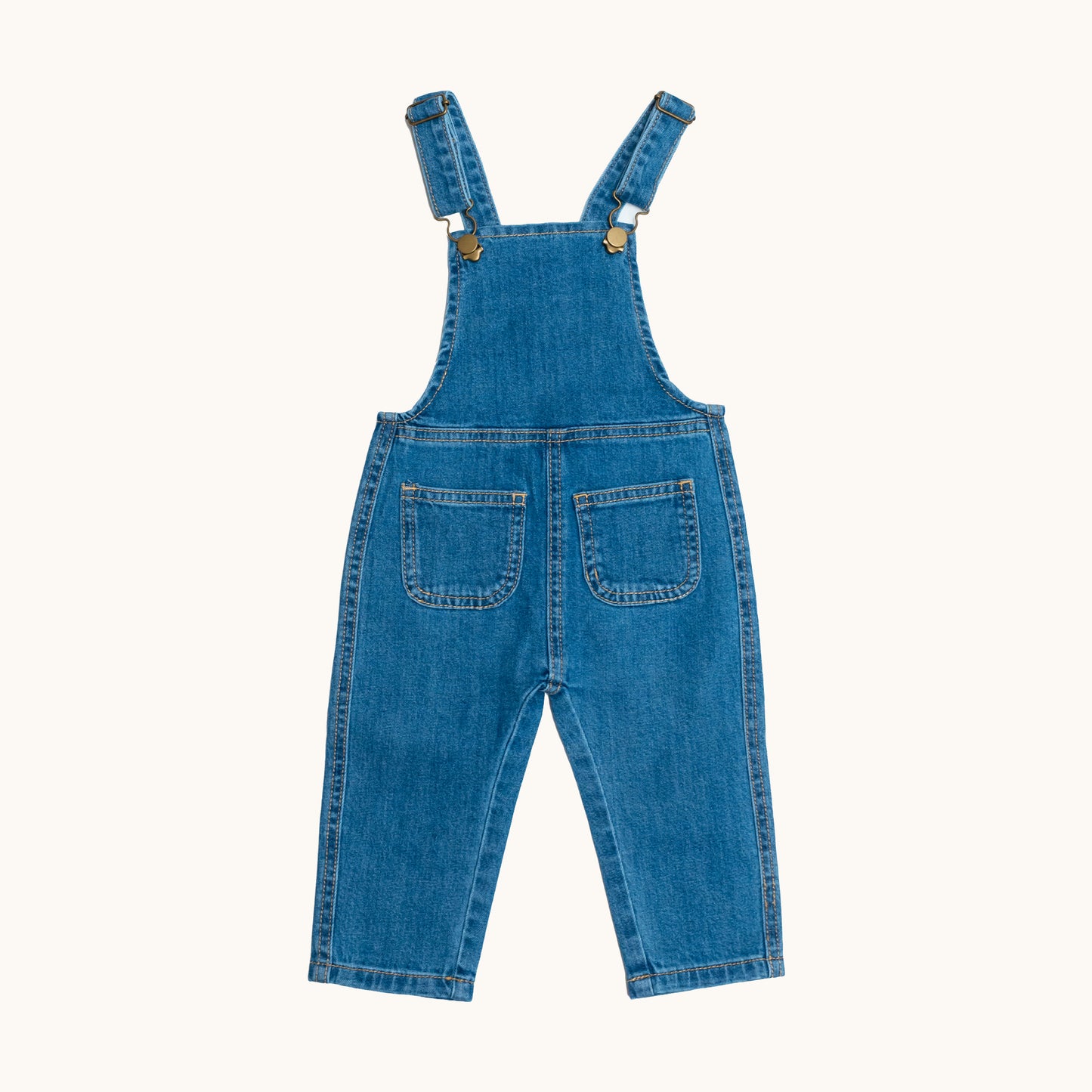 EVERYDAY DENIM OVERALLS; 100% Organic Cotton; Medium-weight denim fabric; Press snaps at the crotch for easy dressing (Size 0 & Size 1); Adjustable straps and front patch pockets; Logo badge at the back.