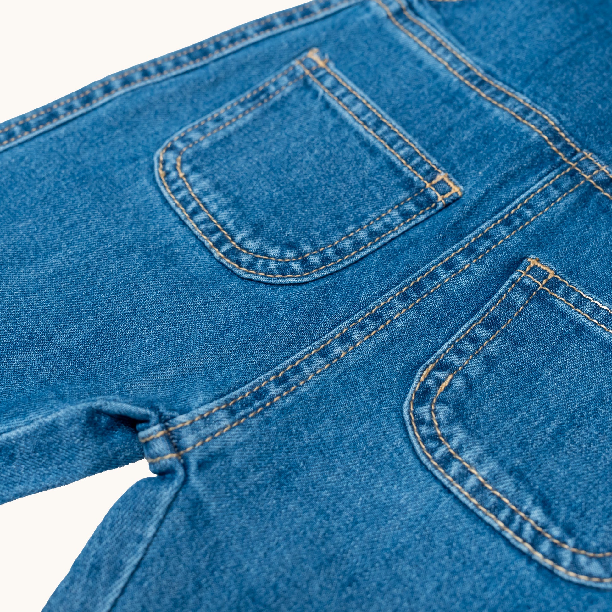 EVERYDAY DENIM OVERALLS; 100% Organic Cotton; Medium-weight denim fabric; Press snaps at the crotch for easy dressing (Size 0 & Size 1); Adjustable straps and front patch pockets; Logo badge at the back.