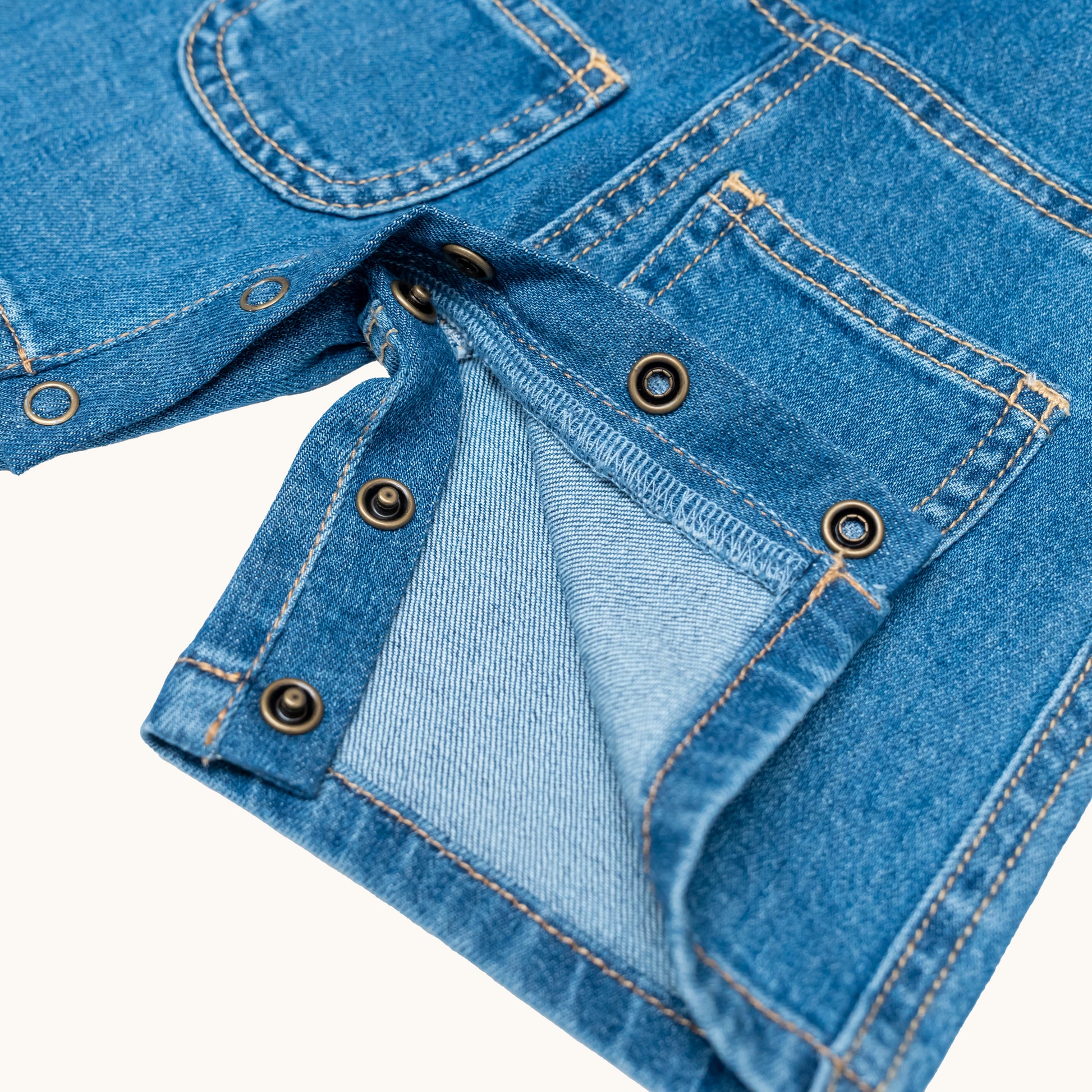 EVERYDAY DENIM OVERALLS; 100% Organic Cotton; Medium-weight denim fabric; Press snaps at the crotch for easy dressing (Size 0 & Size 1); Adjustable straps and front patch pockets; Logo badge at the back.