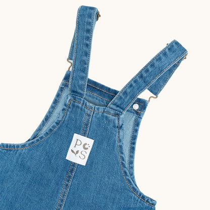 EVERYDAY DENIM OVERALLS; 100% Organic Cotton; Medium-weight denim fabric; Press snaps at the crotch for easy dressing (Size 0 & Size 1); Adjustable straps and front patch pockets; Logo badge at the back.